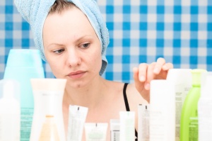 Girl is choosing cosmetics in bathroom